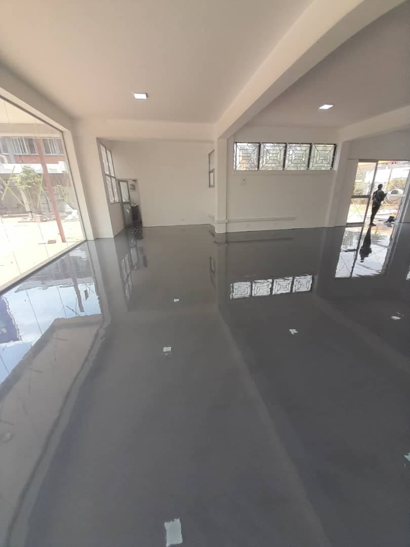 High-gloss dark grey epoxy floor finish in a completed commercial room