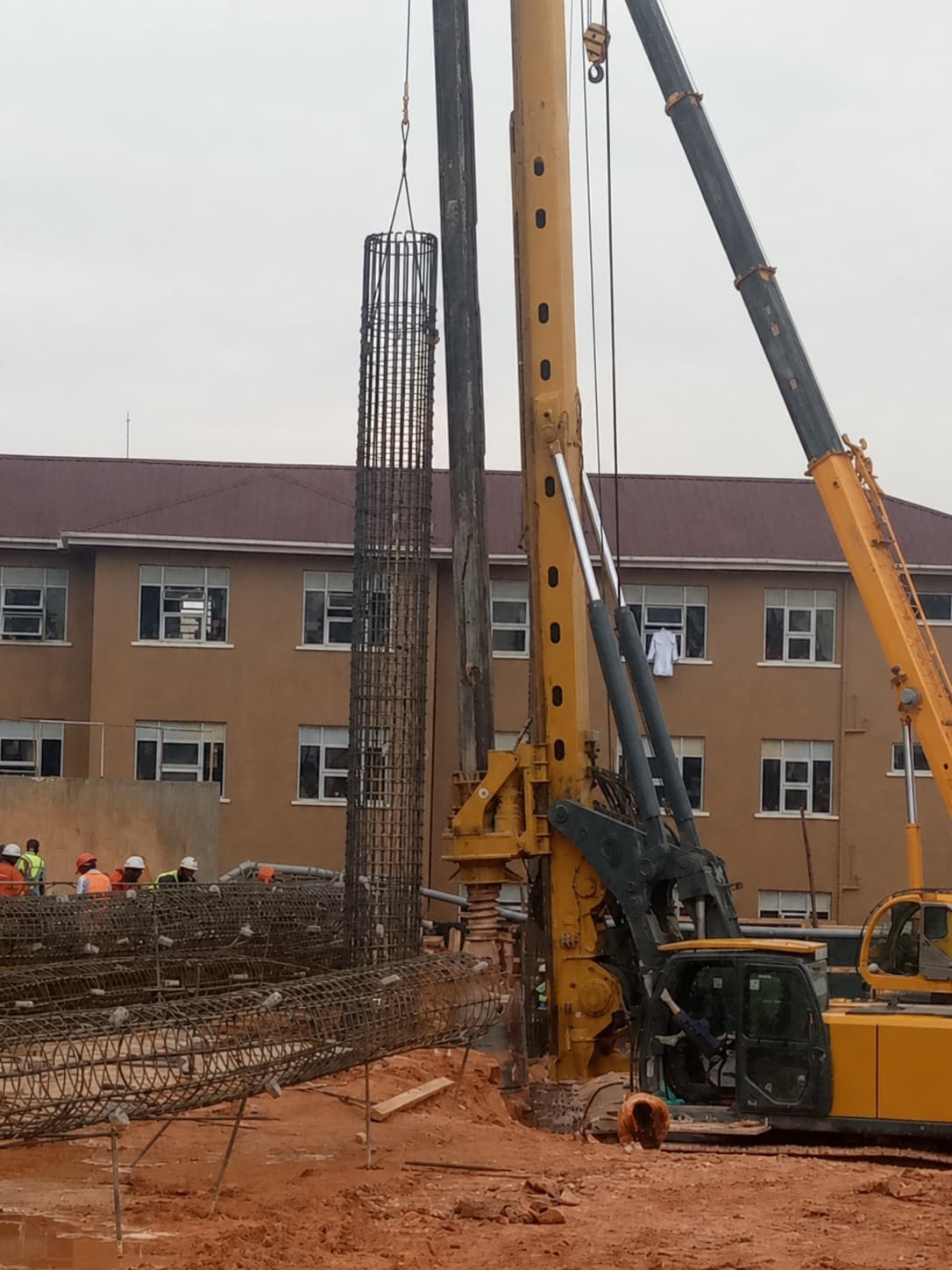 Rotary piling rig installing a reinforced foundation pile